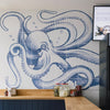 A kitchen interior featuring a large blue octopus mural on a white tiled wall above a curved wooden countertop and dark blue paneled cabinetry.