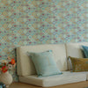 Decorative pillows on a white sofa against a patterned wallpapered wall.