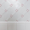 White tiled wall with decorative red floral patterns