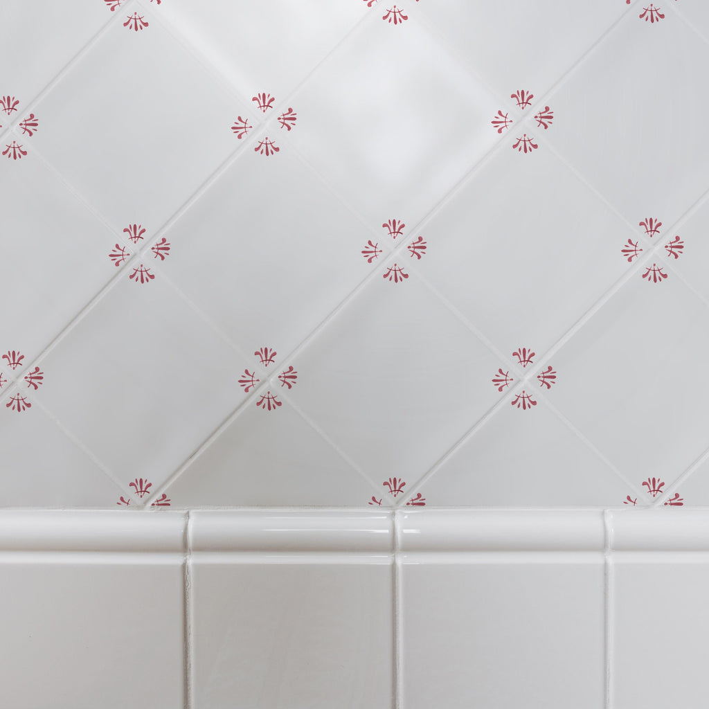 White tiled wall with decorative red floral patterns