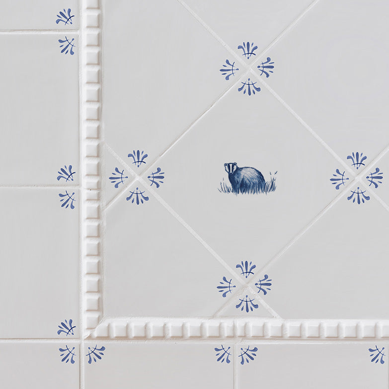 Decorative tiles with a badger design and blue floral patterns on a white background