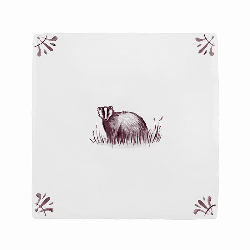 White tile with a badger design and decorative elements on a white background