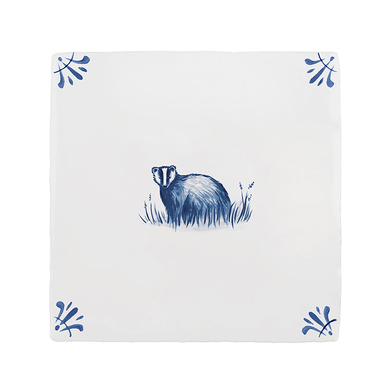 White tile with blue badger design and decorative elements on a white background
