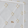 White tiles with mustard floral patterns and a castle design tile on a white background