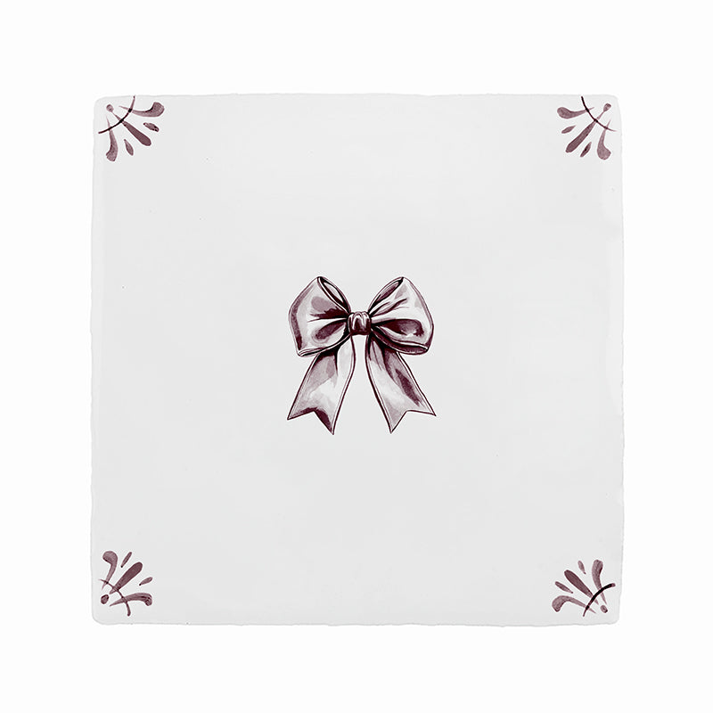 White tile with amanganese bow design on a white background