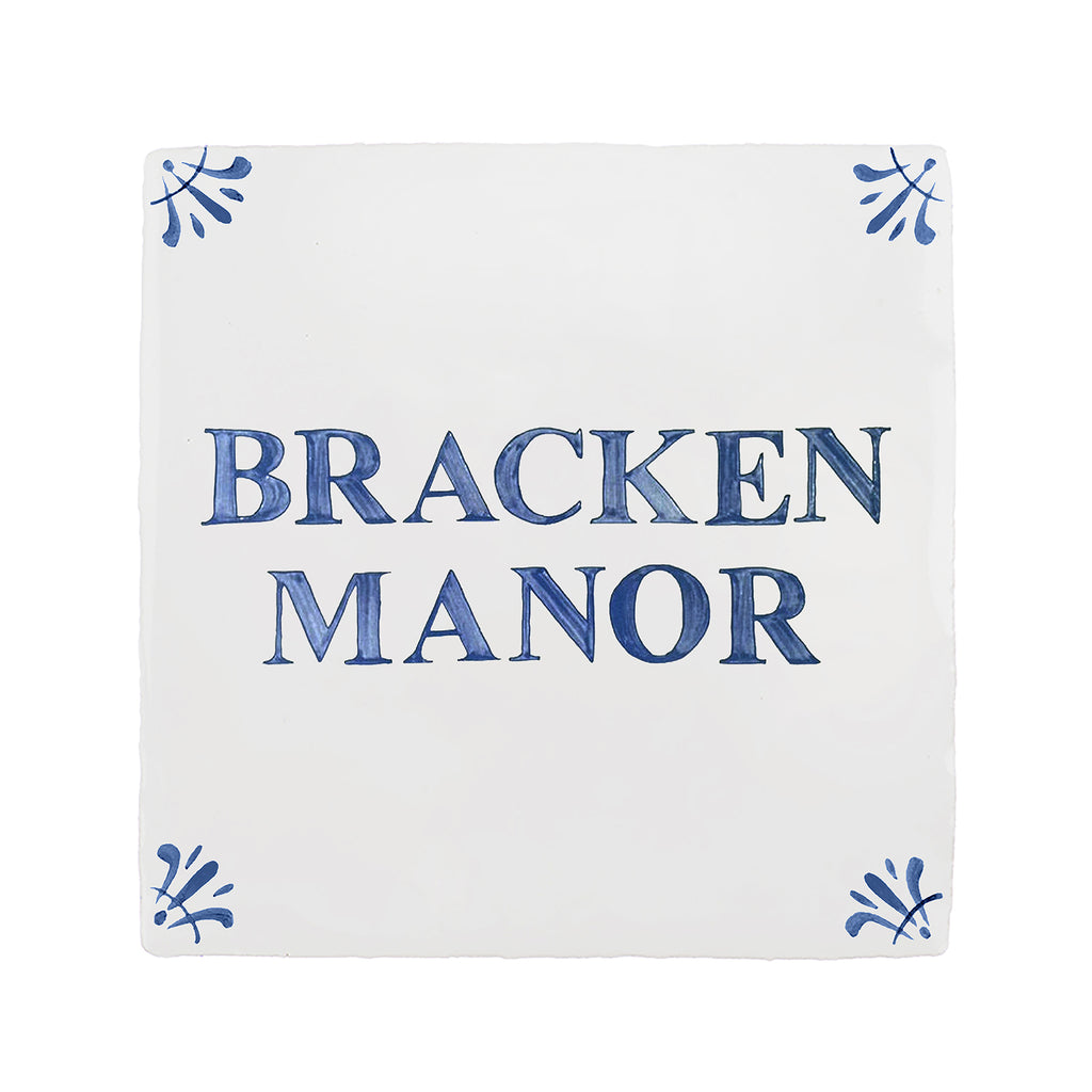 A square white decorative tile or plaque with the words 