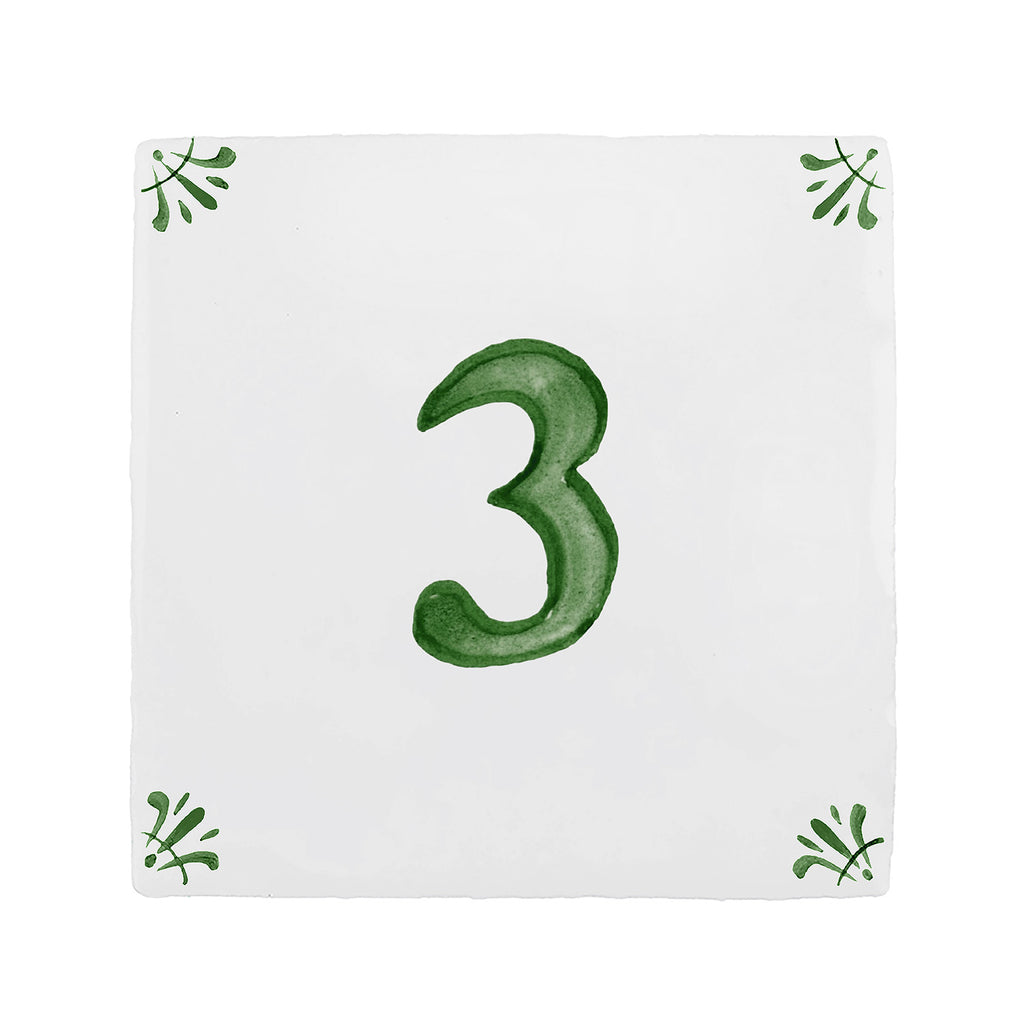 A square white ceramic tile or coaster featuring a hand-painted green number 3 in the center, with small green leafy sprigs in each of the four corners.