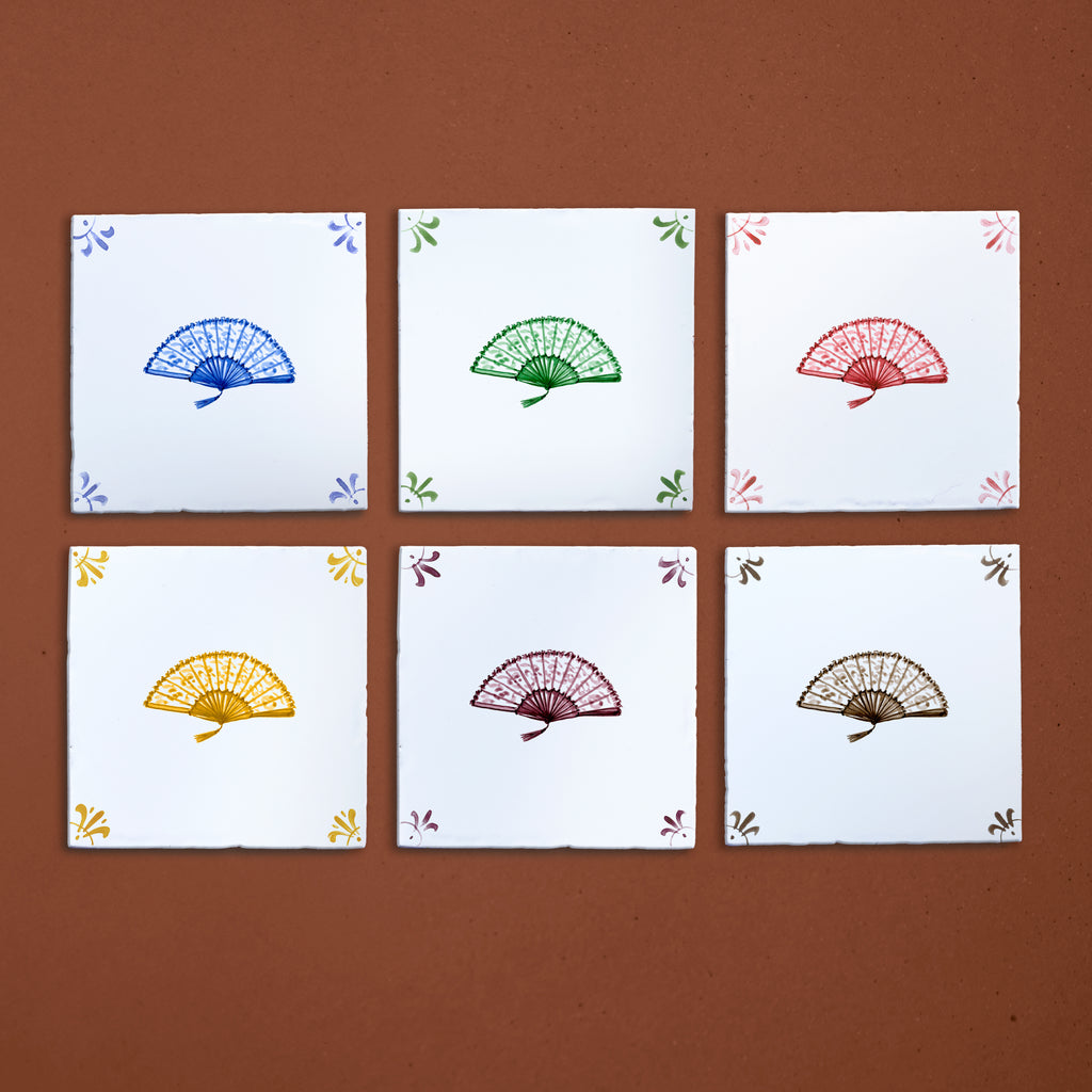 Six tiles with colorful fan designs on a brown background