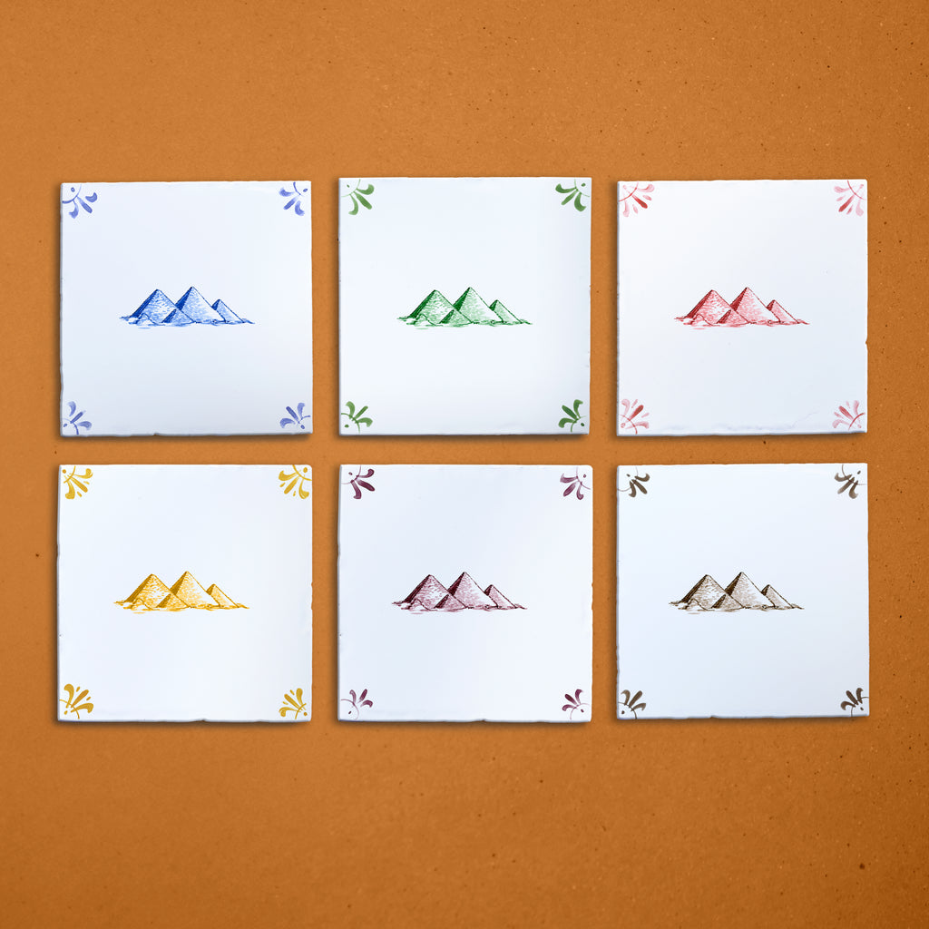 Six tiles with pyramid designs in different colors on a brown background