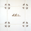 Decorative tile with pyramid design and decorative corners on a tiled wall.
