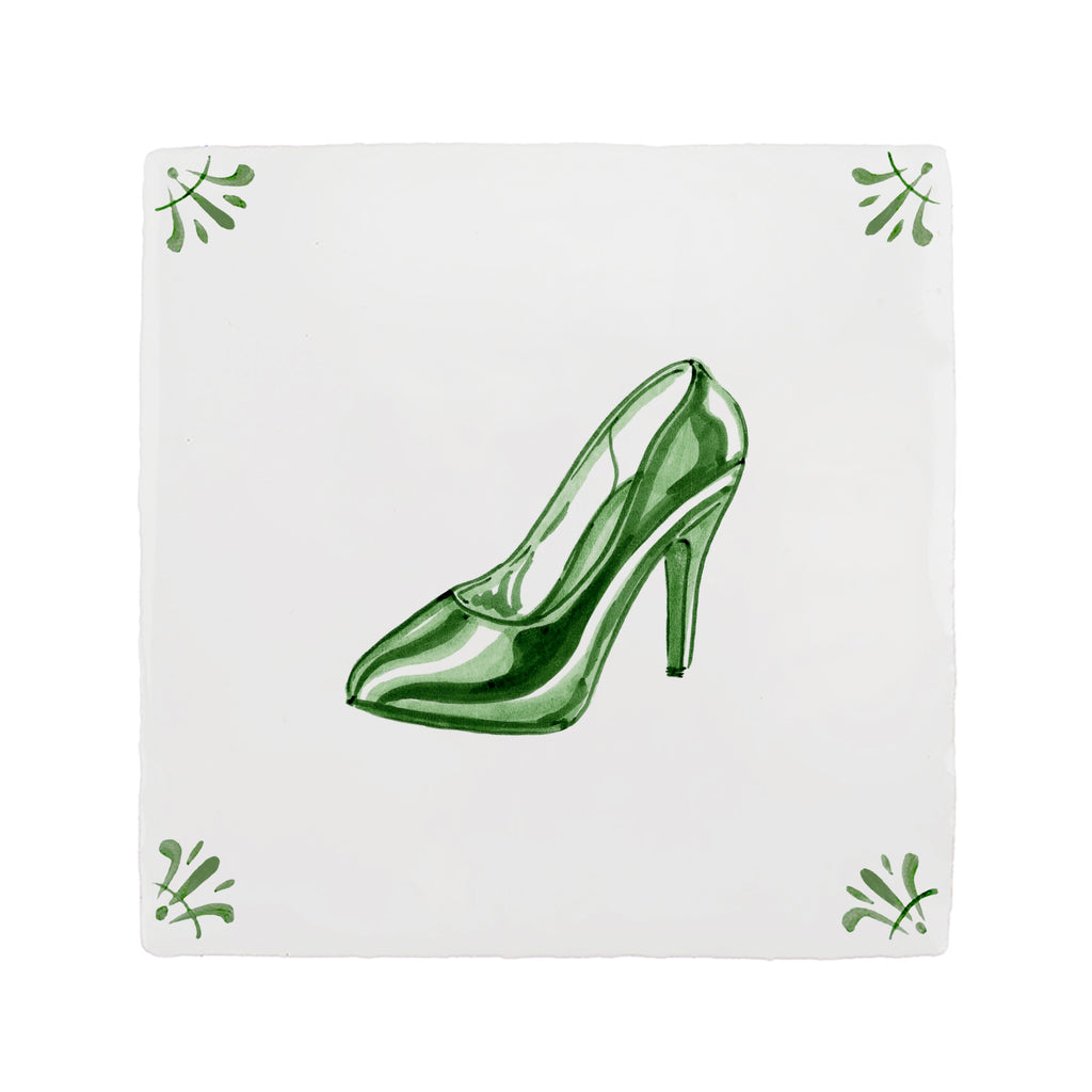 Green high heeled shoe on a white tile background with decorative elements