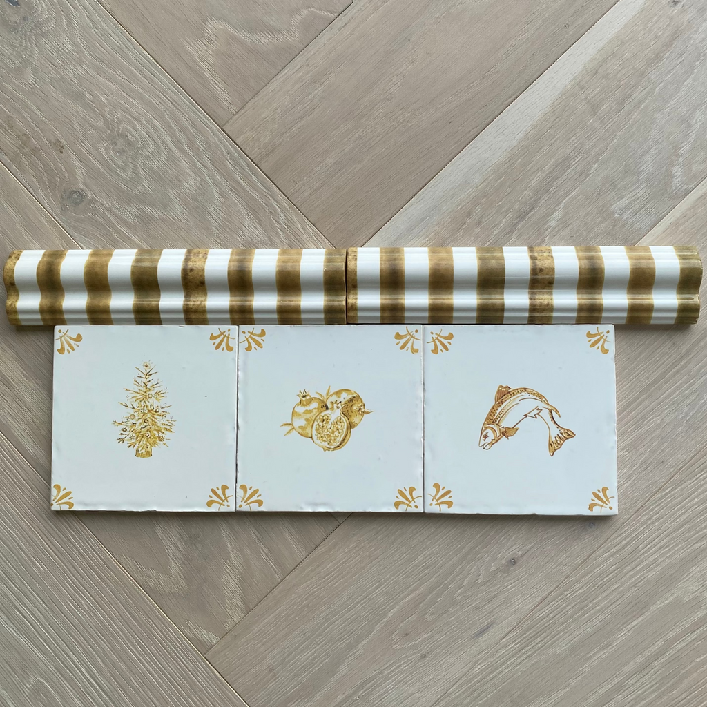 Two striped dado tile trims next to three mustard coloured delft tiles