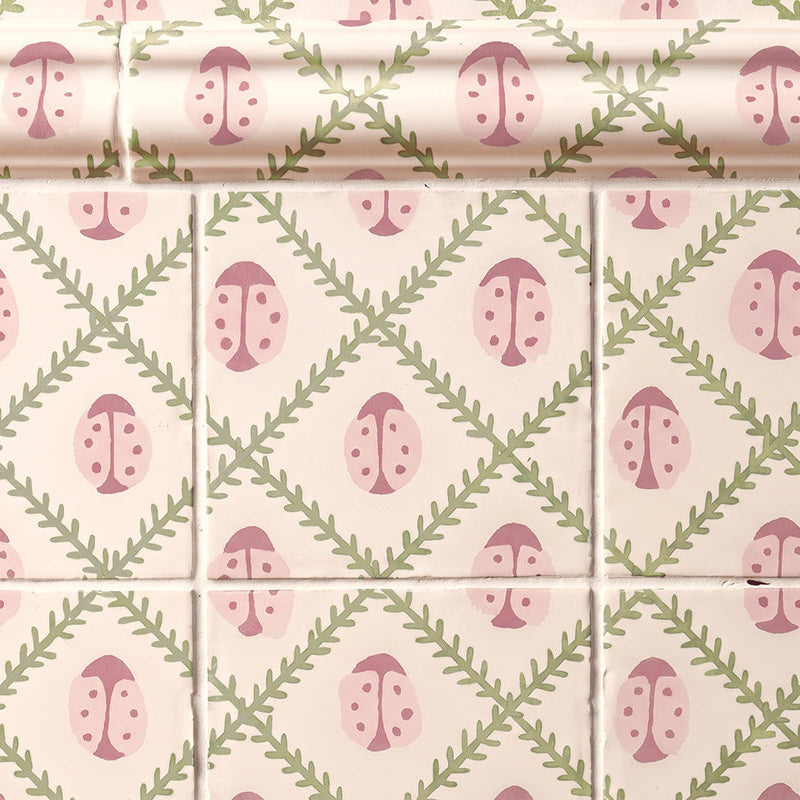 Patterned tiles with pink and green ladybird design on a white background