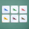 Set of six tiles with colorful illustrations of matcha whisks on a green background
