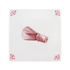 Red matcha whisk on a white tile background with decorative patterns