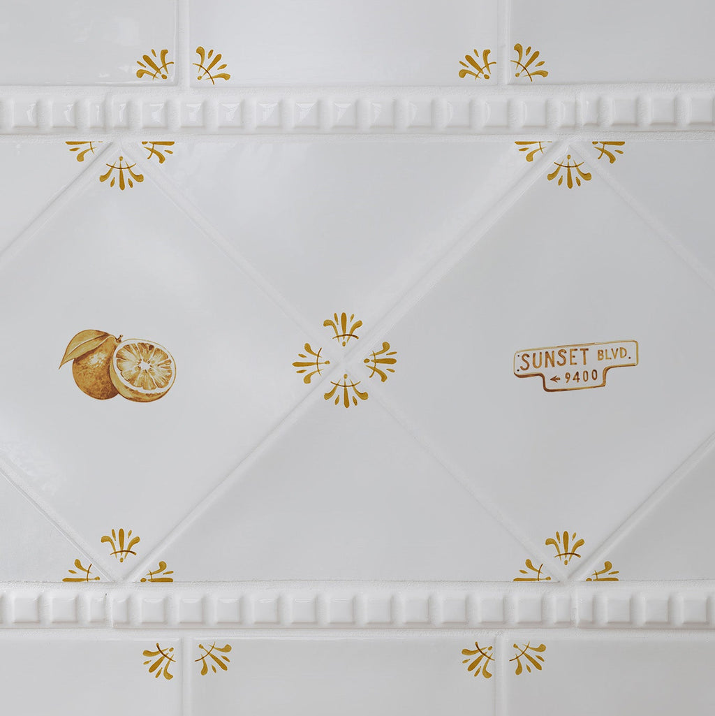 White tiles with mustard details featuring orange and 'Sunset Boulevard' illustrations.