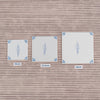 Three square white tiles with blue floral designs are shown on a background of striped wallpaper, comparing the size of a 10cm, 12.5 and 15cm tile