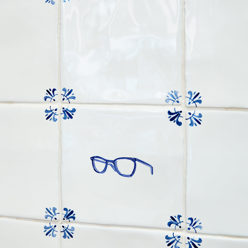 Decorative blue eyeglasses and decorative corner patterns on white tiles