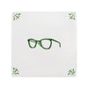 White tile with green eyeglasses design and decorative corner patterns on a white background