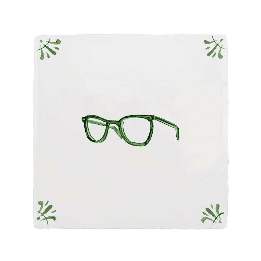 White tile with green eyeglasses design and decorative corner patterns on a white background