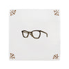 Pair of brown glasses on a white tile with decorative elements