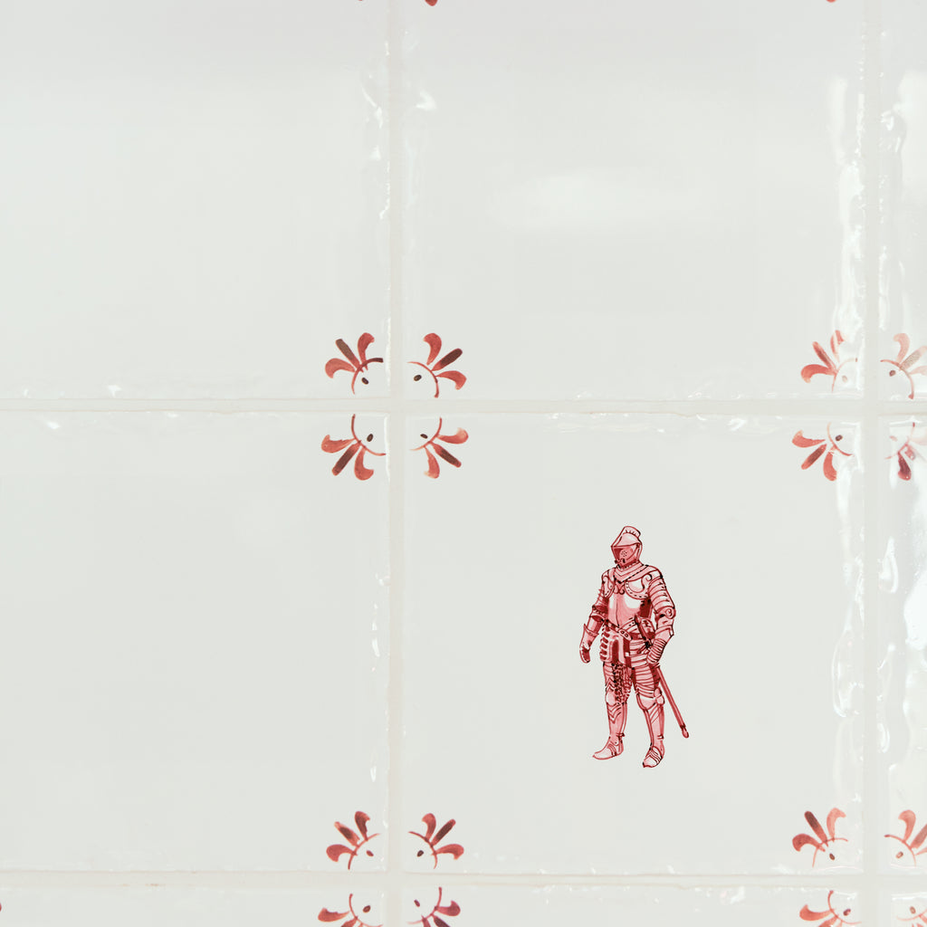 Decorative tiles with a red suit of armour design on a white background