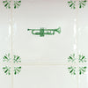 Green trumpet design on a white tiled wall with decorative elements.