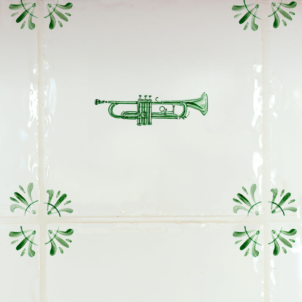 Green trumpet design on a white tiled wall with decorative elements.