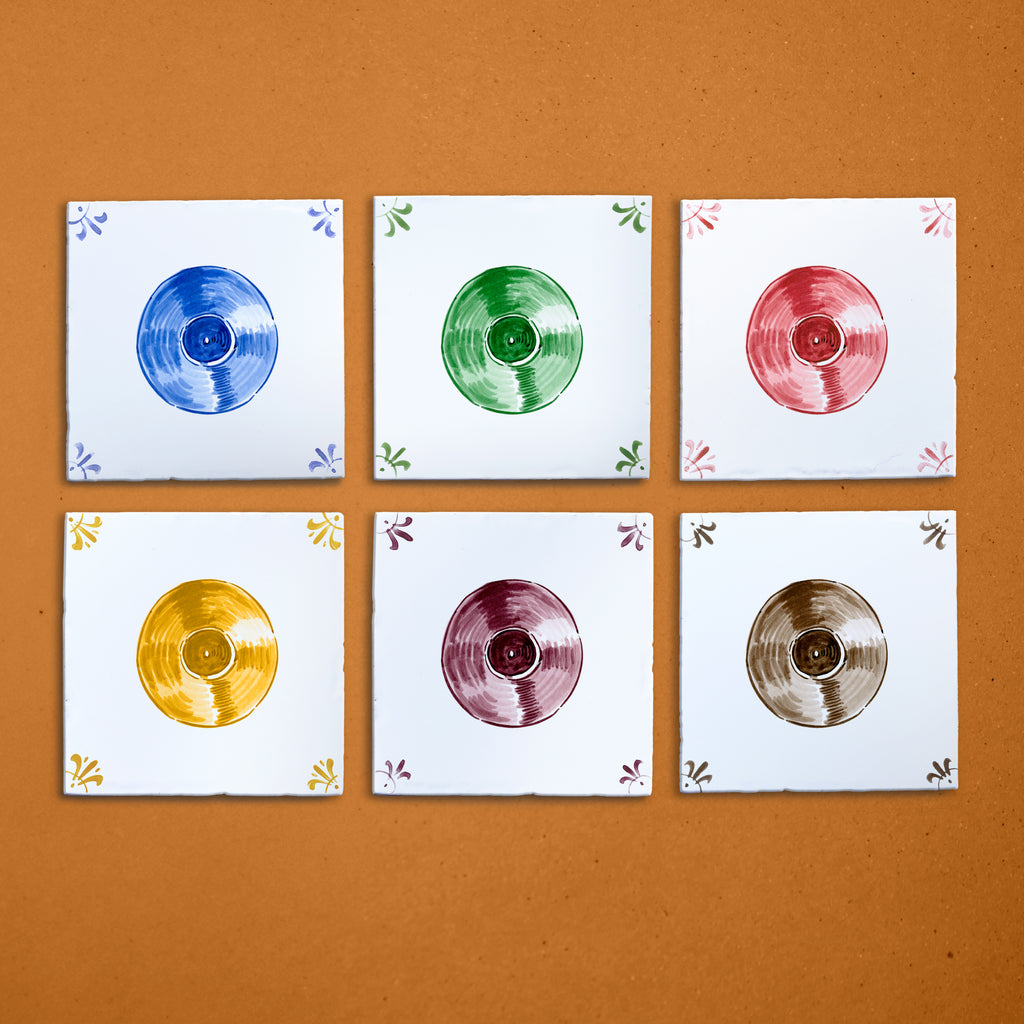 Six square tiles with colorful vinyl record illustrations on a brown background