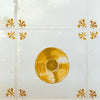 Mustard record on a white tiled background with decorative elements